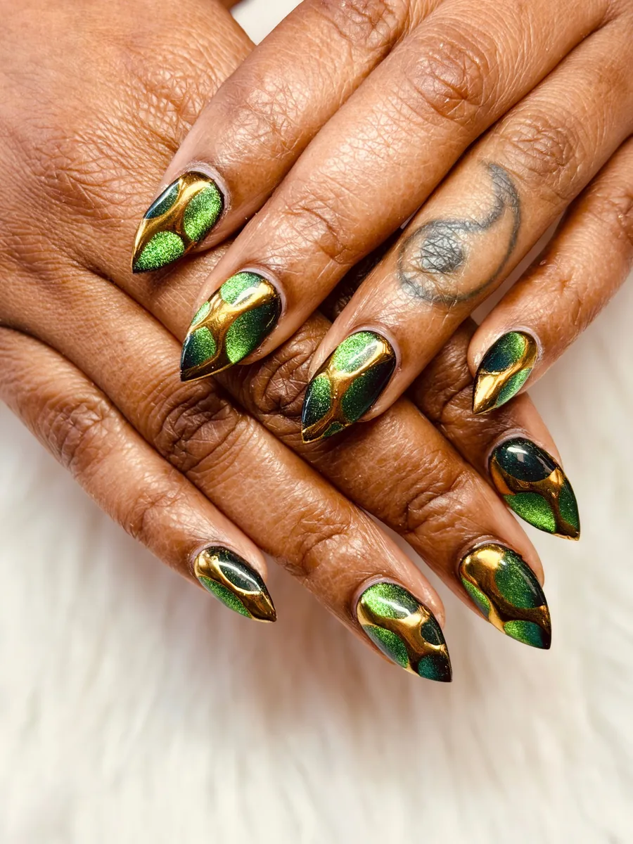 Emerald green cat eye stiletto nails outlined in gold chrome by Hailey Nguyen